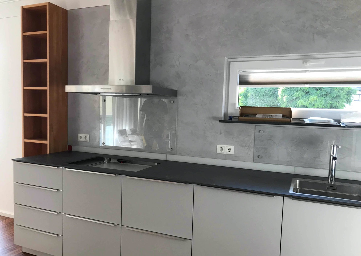 Schöne Küche mit Edelstahlhaube und gespachtelter Rückwand