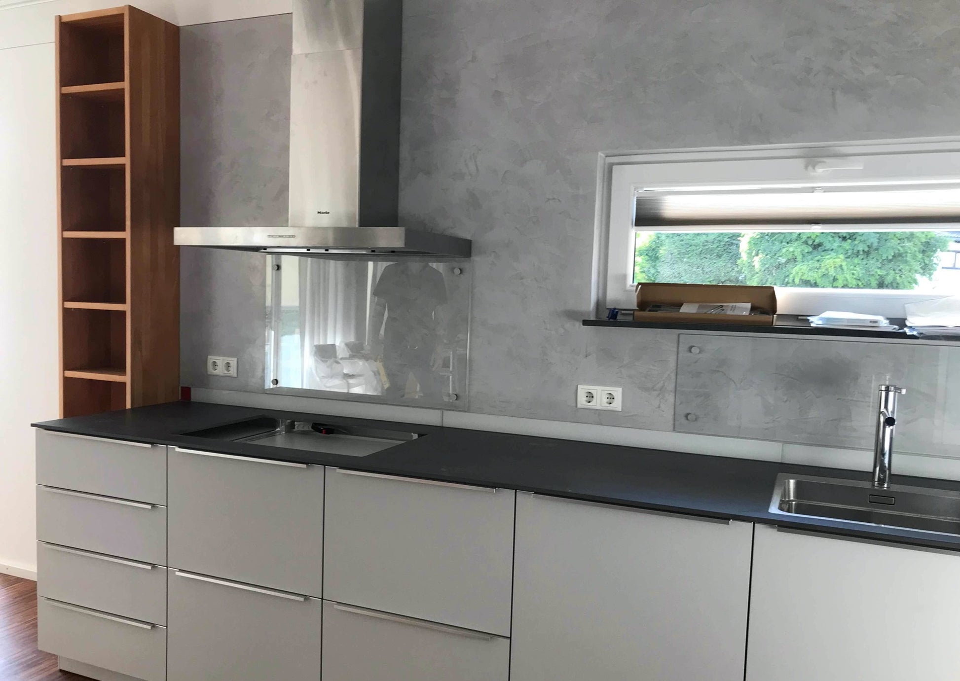 Schöne Küche mit Edelstahlhaube und gespachtelter Rückwand